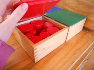 Montessori material to learn width, thickness, size and probably colours, these are the red cylinders.