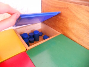 Montessori material to learn width, thickness, size and probably colours, these are the blue cylinders.