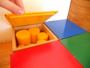 Montessori material to learn width, thickness, size and probably colours, these are the yellow cylinders.