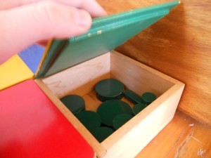 Montessori material to learn width, thickness, size and probably colours, these are the green cylinders.