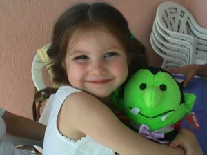 A picture of my daughter when she was 5, holding a Halloween vampire plushie.