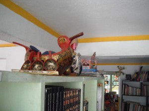 Folk wooden tureen shaped like a bird, it has cups hanging from its rim.