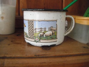 There are two enameled mugs in the kitchen and that like to look at, this one has a scene with sheep.
